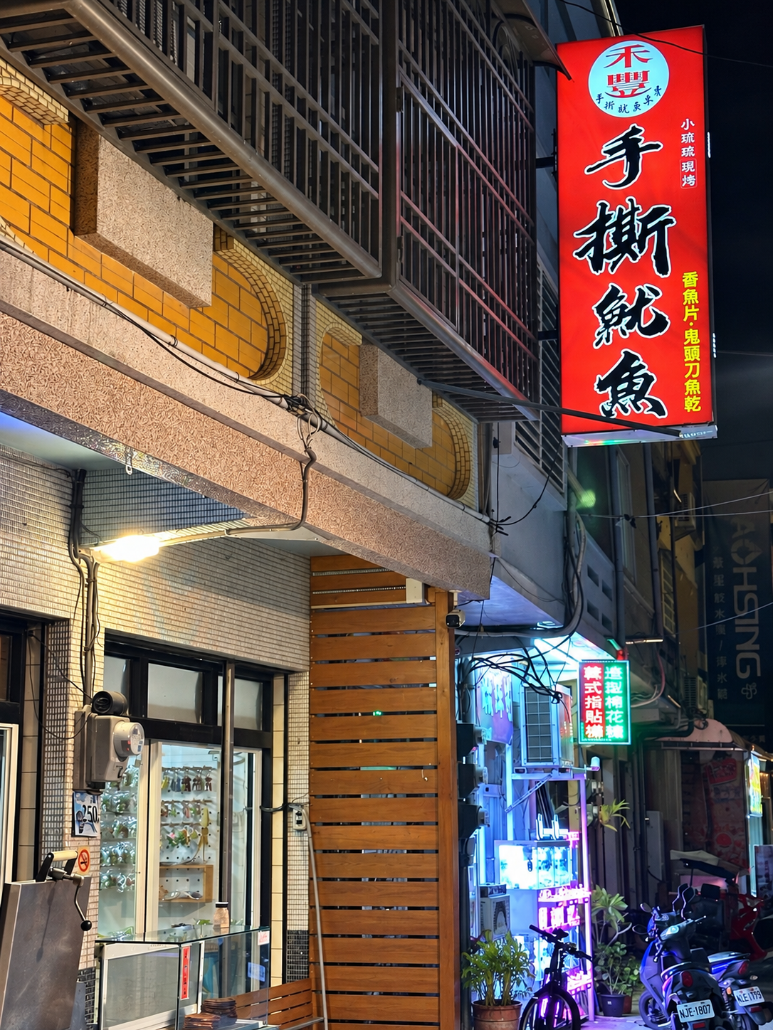 小琉球禾豐手撕魷魚紅色直式招牌,標示現烤魷魚與魚乾品項